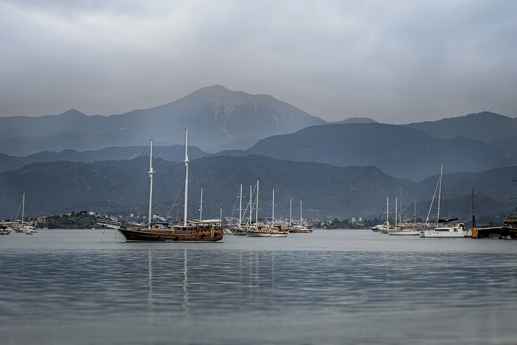 Puslu havada koyda demirlemiş yelkenliler