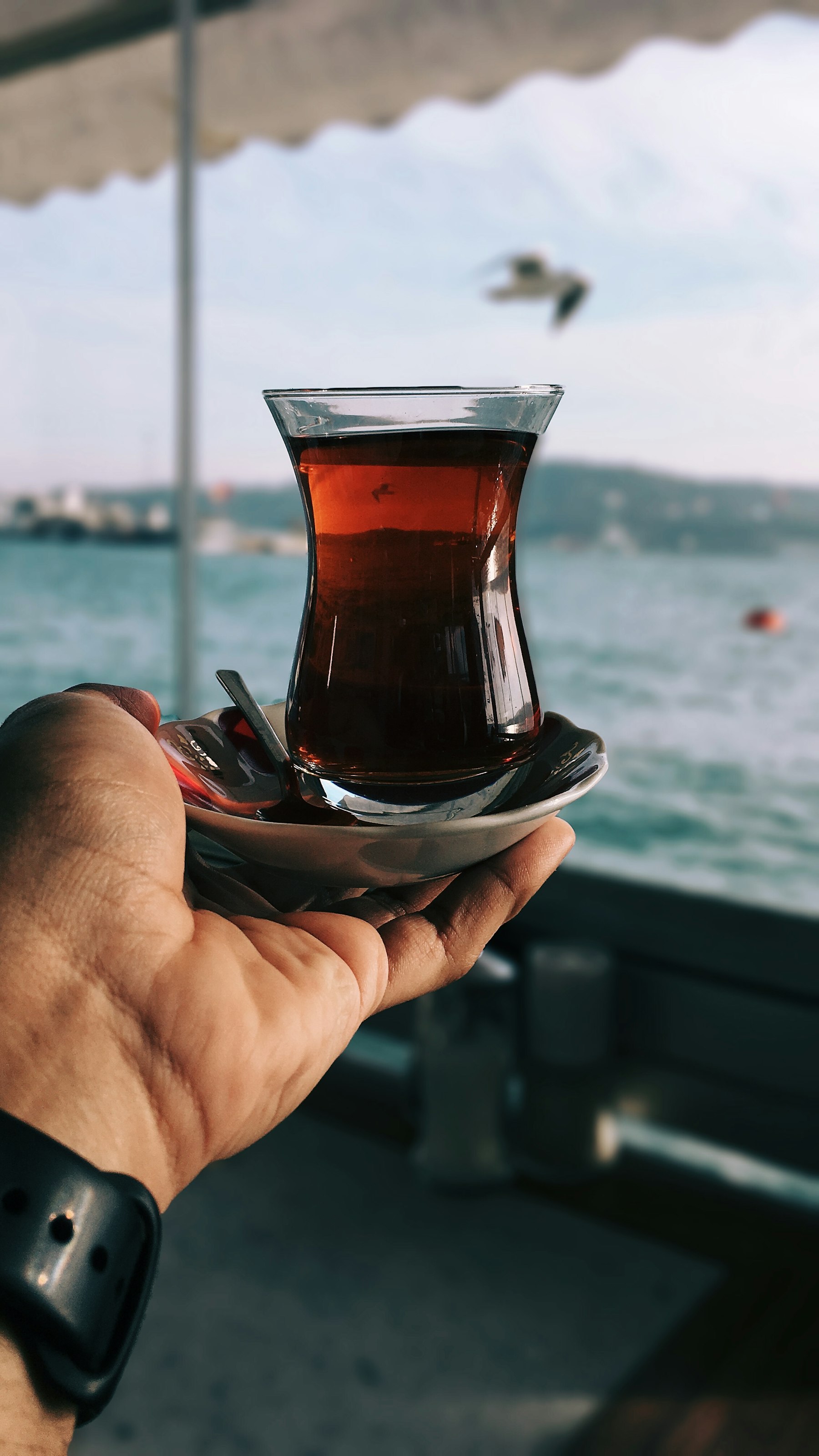 Denize karşı elde ince belli çay bardağı